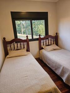 two beds in a room with a window at Casa em Chácara com Cacheira in Muzambinho +26 photos