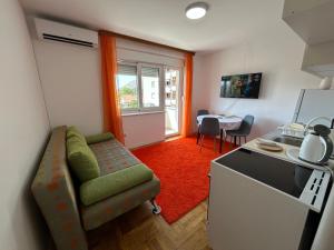 a small living room with a couch and a kitchen at Apartman Azra in Trebinje