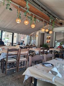 Un restaurante con mesas y sillas de madera y luces. en Villa Desire, en Mesochórion