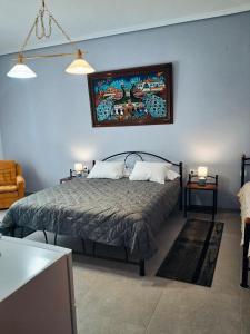 a bedroom with a bed with a painting on the wall at Villa Desire in Korinos