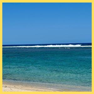 Ti Caz Lagon I T2 I piscine Front de mer Hermitage في Saint-Paul: شخص يقف على شاطئ قريب من المحيط