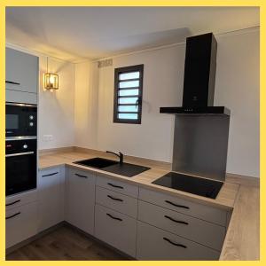 Ti Caz Lagon I T2 I piscine Front de mer Hermitage في Saint-Paul: مطبخ بخزائن بيضاء ومغسلة ونافذة