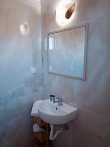 Un baño con un lavabo y un espejo en la pared. en Villa Desire, en Mesochórion