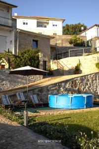 a couple of chairs and an umbrella next to a wall at Quinta Dos Sonhos in Vale de Cambra