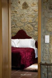 a bedroom with a bed with a stone wall at Quinta Dos Sonhos in Vale de Cambra