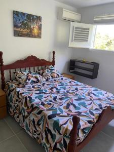 Una cama con un edredón colorido en un dormitorio. en Gwada vacances, en Sainte-Rose