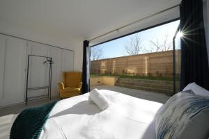 イーリングにあるEaling Broadway Great Stay 7-Minute Walk from the Undergroundのベッドと大きな窓のある寝室