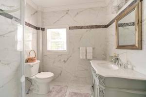 biała łazienka z toaletą i umywalką w obiekcie Near Lake Erie, Harbor and Parks Conneaut Getaway! w mieście Conneaut +29 zdjęć