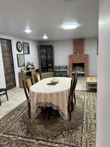 a dining room with a table and chairs and a fireplace at Guest Hause Lile in Tsʼageri