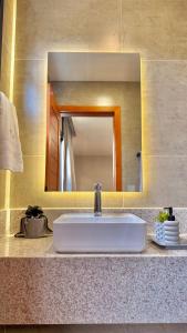 ein weißes Waschbecken in einem Badezimmer mit einem Spiegel in der Unterkunft Casa Morada do Lago in Santa Maria