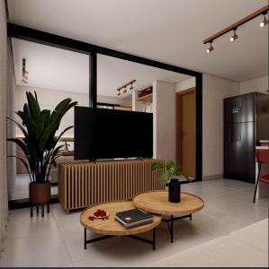 un soggiorno con tv e tavolo di Jubarte Flats a Itacaré