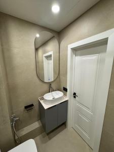 a bathroom with a sink and a mirror at Уютная квартира в центре города in Almaty
