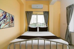 Un dormitorio con una cama y una ventana en Hotel O KASHIKAA JUNGLE VIEW, en Bhubaneshwar