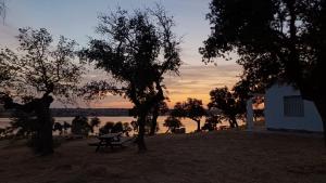 een picknicktafel voor een meer bij zonsondergang bij Casas rurales La Colada in El Viso