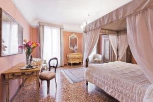 a bedroom with a bed and a table with flowers on it at Palazzetto San Lio, Rialto in Venice