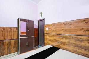 a room with a bed and a wooden wall at Hotel O Pushpanjali in Haldwāni +26 photos