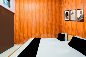 a bedroom with a bed with a wooden wall at Hotel O Pushpanjali in Haldwāni