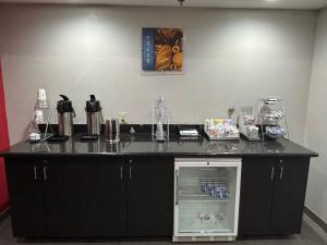 a counter with an open refrigerator in a room at Ramada by Wyndham Burkburnett - Wichita Falls in Burkburnett