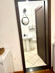 a bathroom with a sink and a toilet and a door at Central Studio With Parking in Arad +5 photos