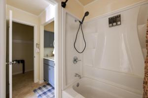 a bathroom with a shower and a bath tub at 6 Mi to the Summit Stylish Apt with Patio Access in Wisteria Commons +16 photos