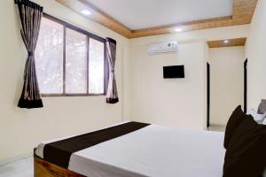 a bedroom with a bed and a window at Hotel O Bhiwandi Road Railway Station Formerly Shivneri in Bhiwandi