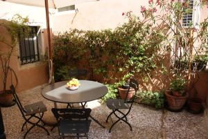 a table and chairs in a courtyard with plants at Palazzetto San Lio, Rialto in Venice