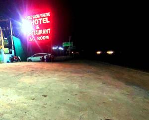 a lit up sign in a parking lot at night at Shree Siddhi Vinayak Hotel & Restaurant in Bargi +22 photos