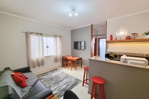 a living room with a couch and a kitchen at Costa Family-Apartment in the center in Santa Rita do Sapucaí