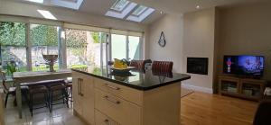 a kitchen with a counter and a tv in a room at Beautiful 3BD Home Beside Phoenix Park in Dublin +19 photos