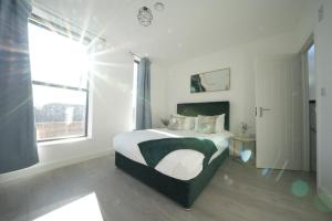 a white bedroom with a bed and a window at Ealing Broadway Great Stay 7-Minute Walk from the Underground in Ealing