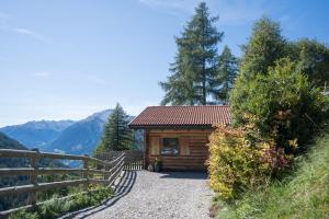 eine kleine Hütte in den Bergen mit einem Zaun in der Unterkunft Chalet Leitn-Anger in St. Leonhard in Passeier