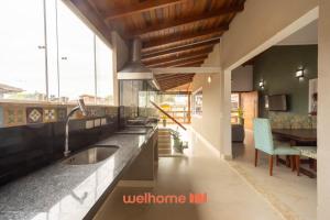 eine Küche mit einem Waschbecken und einem Esszimmer in der Unterkunft Casa em Maresias com Churrasqueira e area de lazer in Maresias