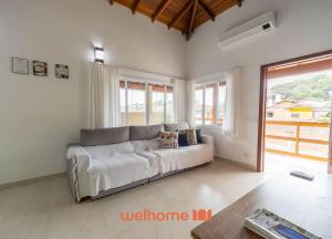 a living room with a white couch and a window at Casa em Maresias com Churrasqueira e area de lazer in Maresias +30 photos