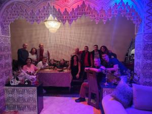 a group of people posing for a picture in a room with purple lighting at Riad Andalousse in Meknès