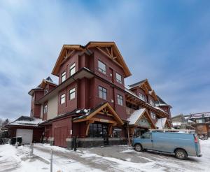 キャンモアにあるMcAuley Manor - Mountain Views Downtown Locationの車が向かいに停まった建物