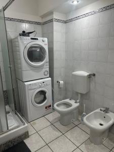 a bathroom with a washing machine and a toilet at Stazione Di Corticella in Bologna