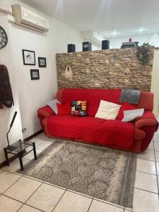 a red couch in a living room with a brick wall at Stazione Di Corticella in Bologna