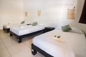 a room with three beds and a sink in it at We playa Hotel - Adults Only in Playa del Carmen