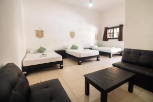 a living room with two beds and a couch at We playa Hotel in Playa del Carmen +45 photos