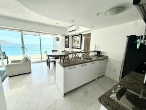 a kitchen and dining room with a view of the ocean at Park Royal 809 Vista al Mar in Mazatlán