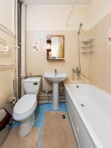 a bathroom with a toilet and a sink and a tub at Апартамент с восхитительным видом на горы и огни города in Almaty