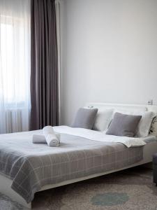 a white bed in a room with a window at Апартамент с восхитительным видом на горы и огни города in Almaty