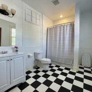 a bathroom with a toilet and a black and white checkered floor at Washington Hotel in Princess Anne