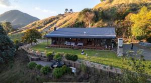 a house on a hill with a mountain in the background at Muirs Reef Lodge Kinloch holiday home Lake Taupo in Kinloch