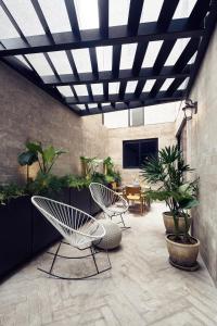 a patio with two chairs and a table at Frida by Viadora in Mexico City