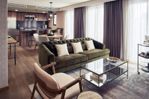 a living room with a green couch and a kitchen at Frida by Viadora in Mexico City