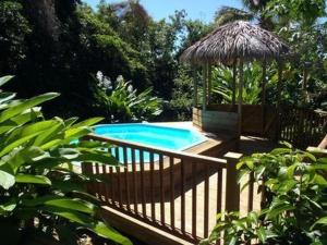 a swimming pool with a gazebo and a swimming pool at Les Balisiers a 450m de la plage in Deshaies