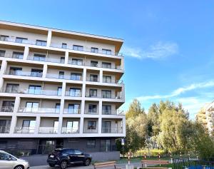 a car parked in front of a large building at Notting Hill Apartament in Rzeszów