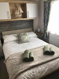 a bedroom with a large bed with towels on it at Littlesea Holiday Park - Holiday Accommodation 15976 in Wyke Regis