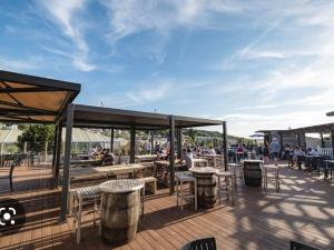 a patio with tables and chairs and people sitting at tables at Littlesea Holiday Park - Holiday Accommodation 15976 in Wyke Regis